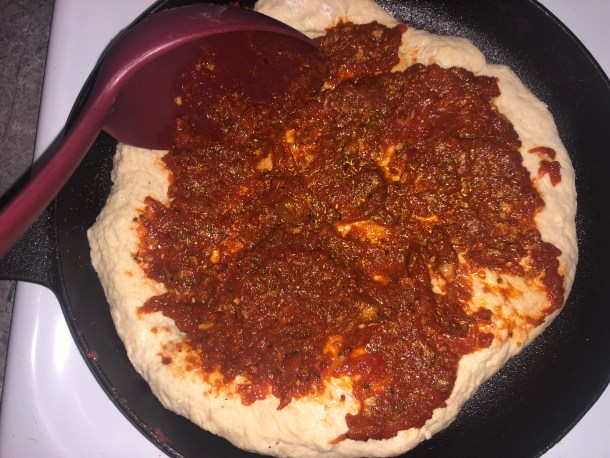 Cooking Eorzea | Adding pizza sauce to the pizza dough.